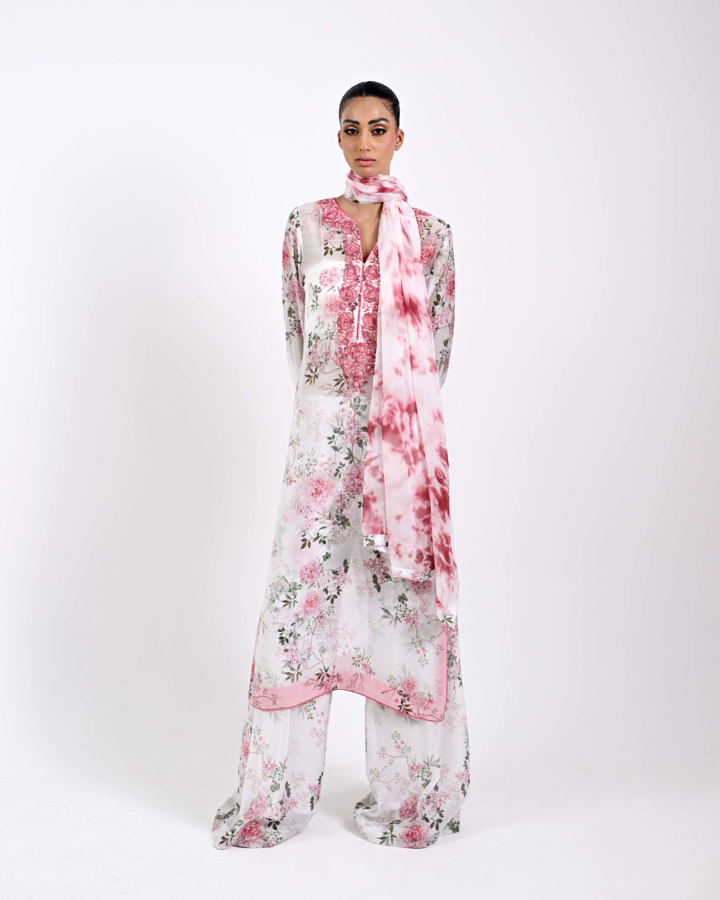 Woman wearing a floral dress and matching scarf on a white background