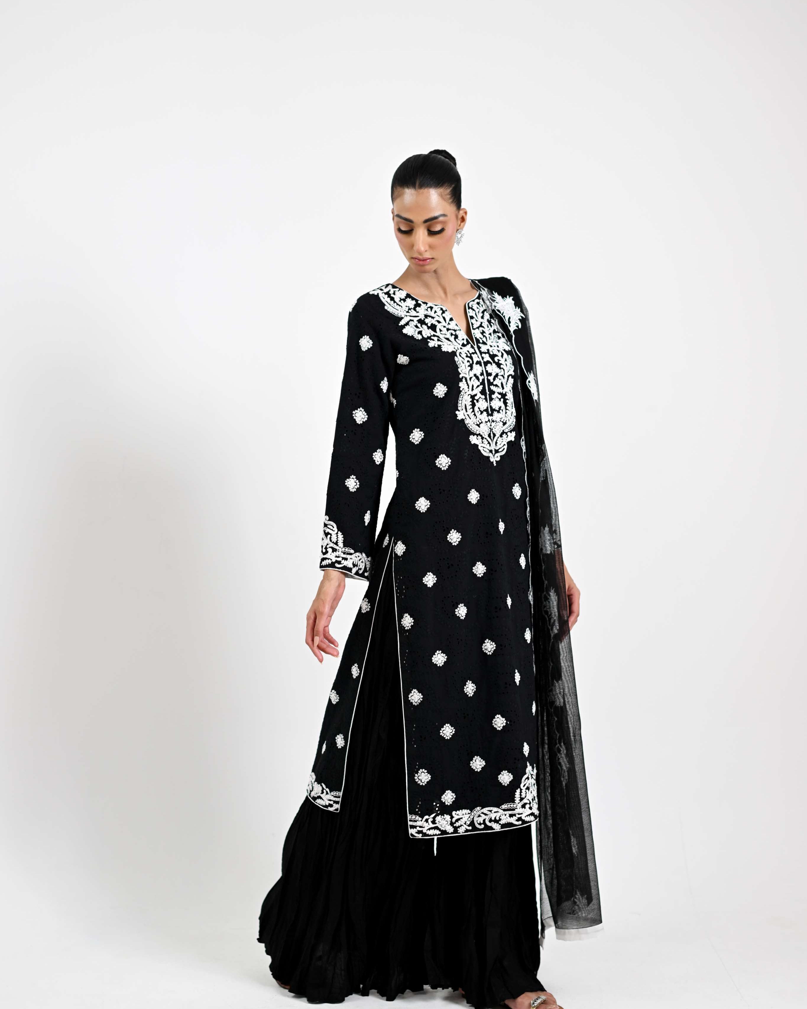 Black traditional outfit with white embroidery on a white background
