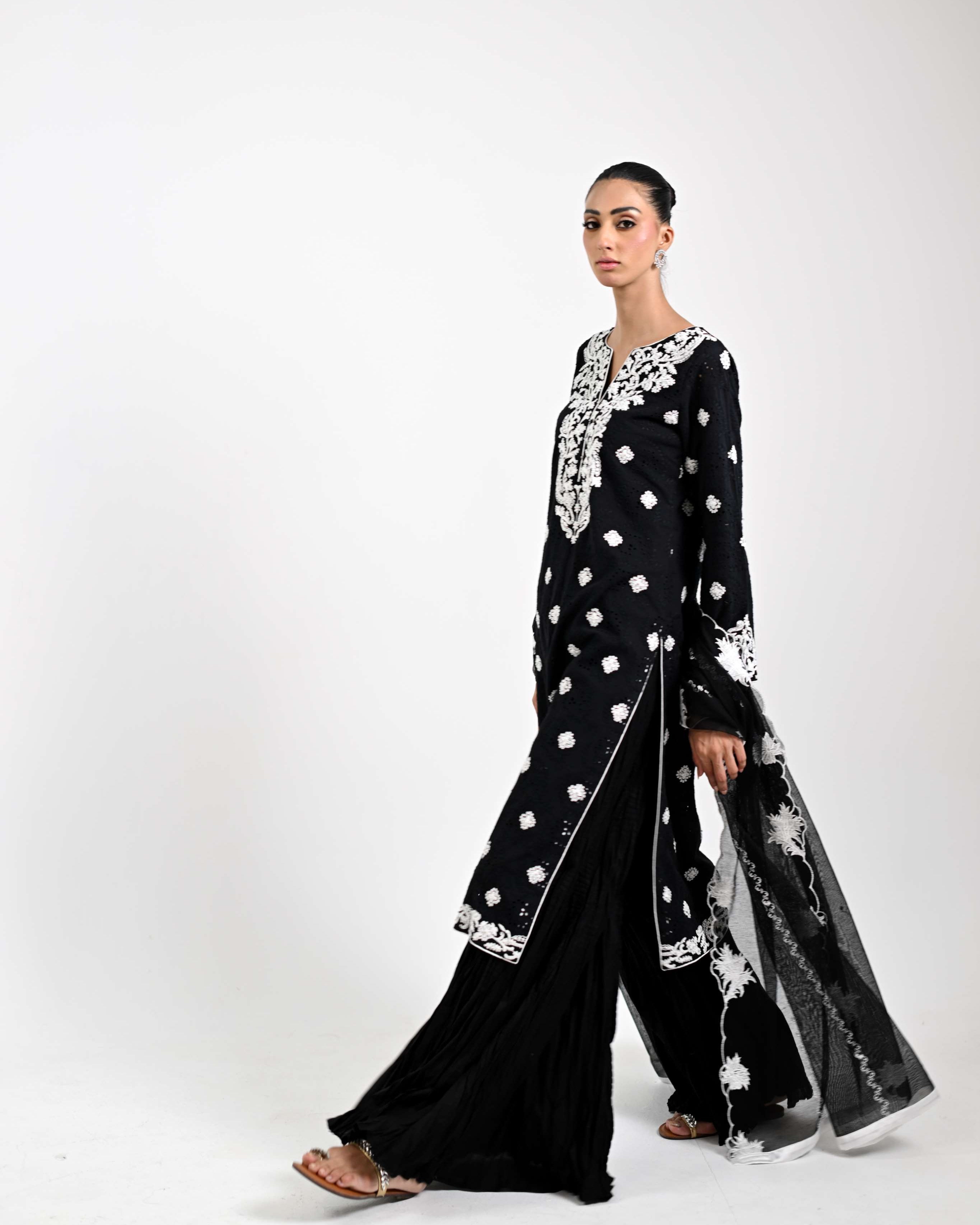 Woman wearing a black and white patterned outfit on a white background