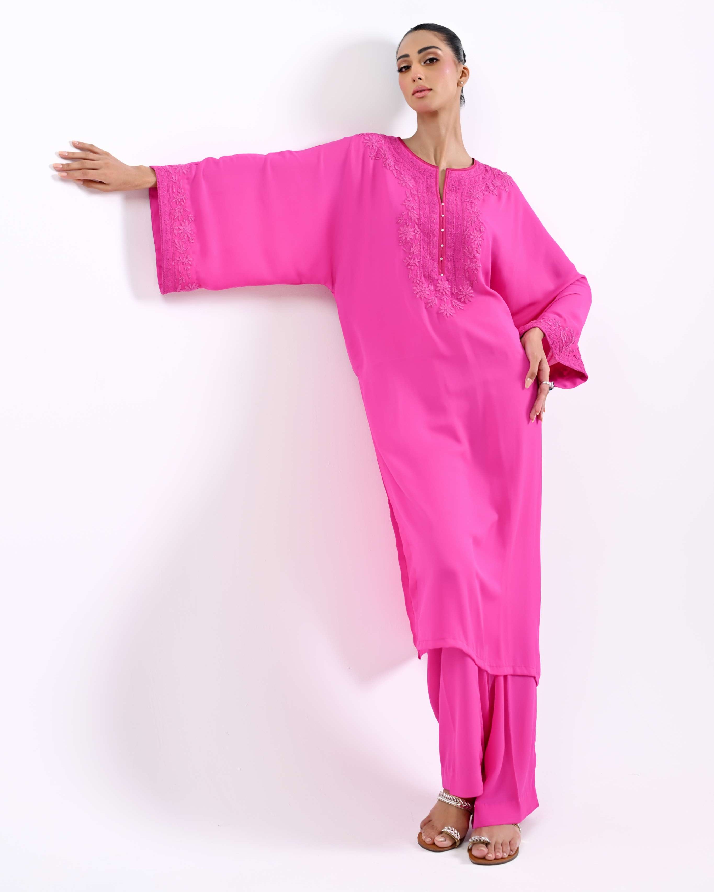 Woman wearing a bright pink traditional outfit on a white background