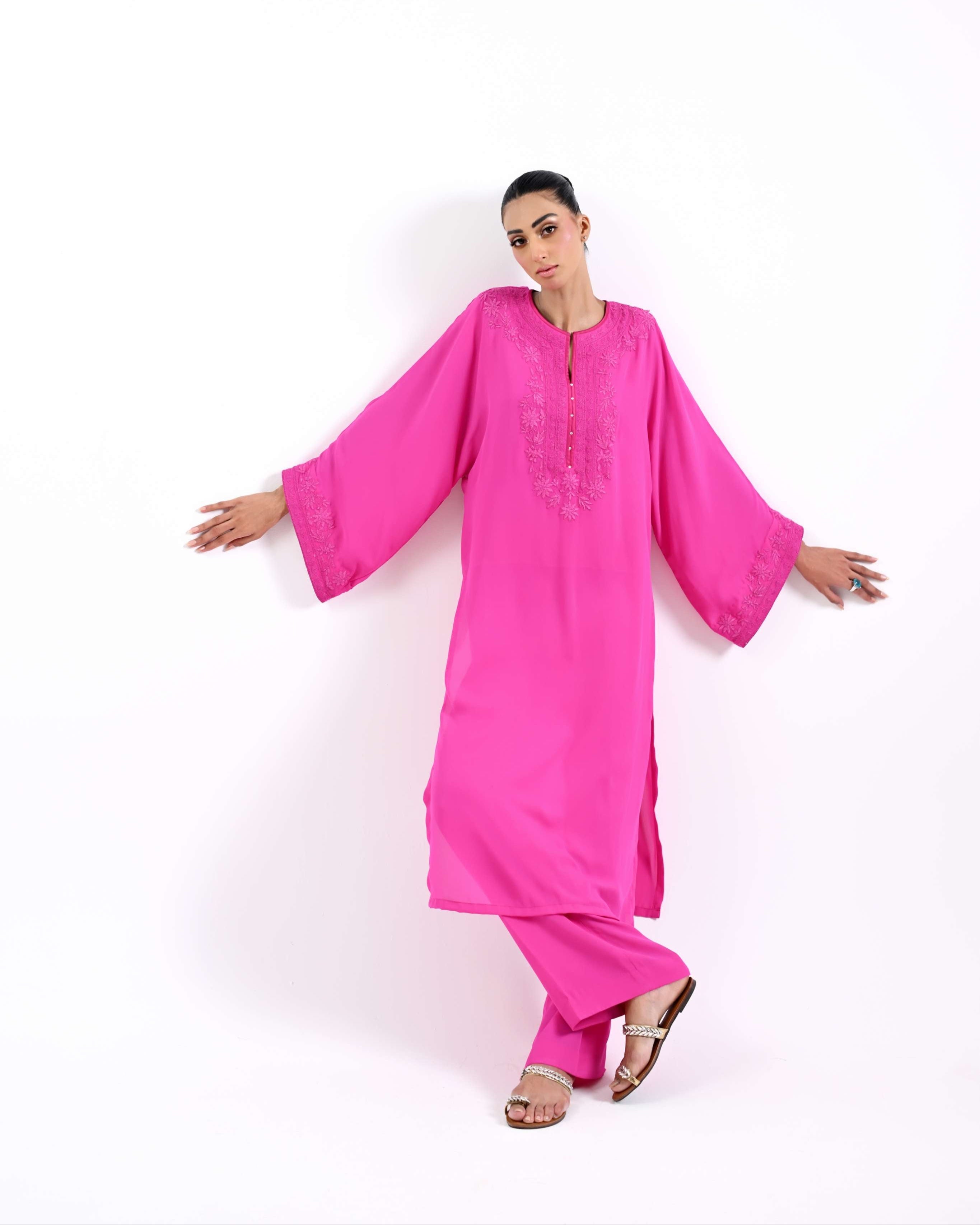 Person wearing a bright pink traditional outfit on a white background