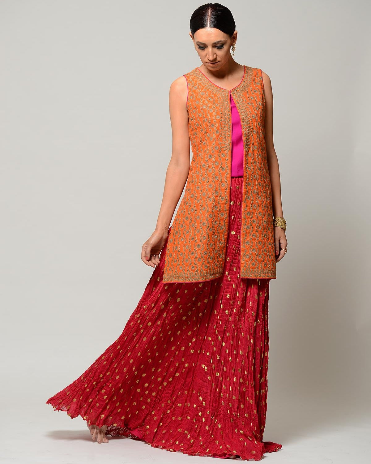 Woman wearing an orange and red traditional outfit on a white background