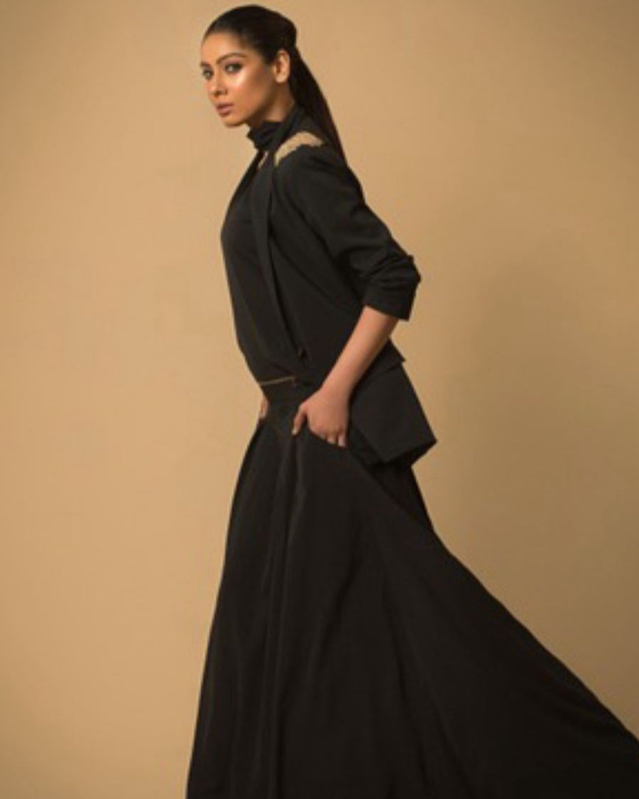 Woman wearing a black outfit against a beige background